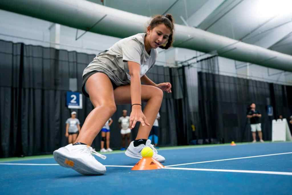 A tennis player undergoing fitness testing and agility monitoring on a court.