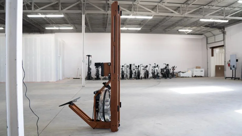 The Ergatta rower standing upright against a wall in a tidy home setting.