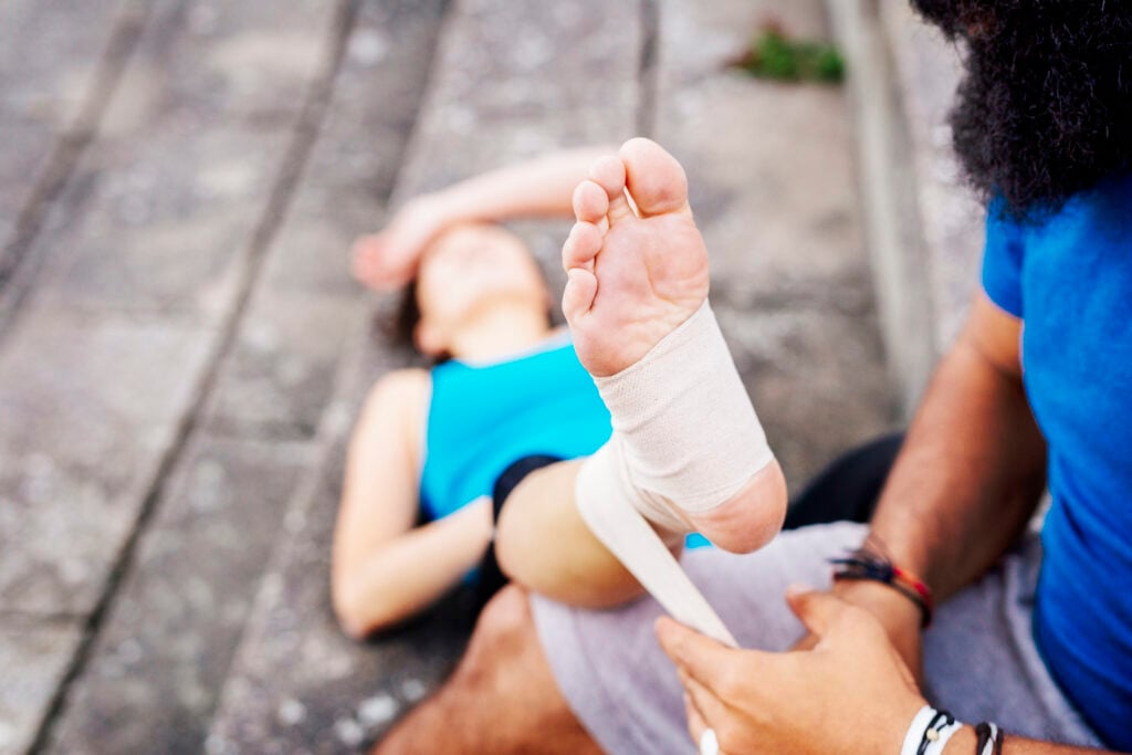 A foot wrapped in a bandage and elevated on a pillow.