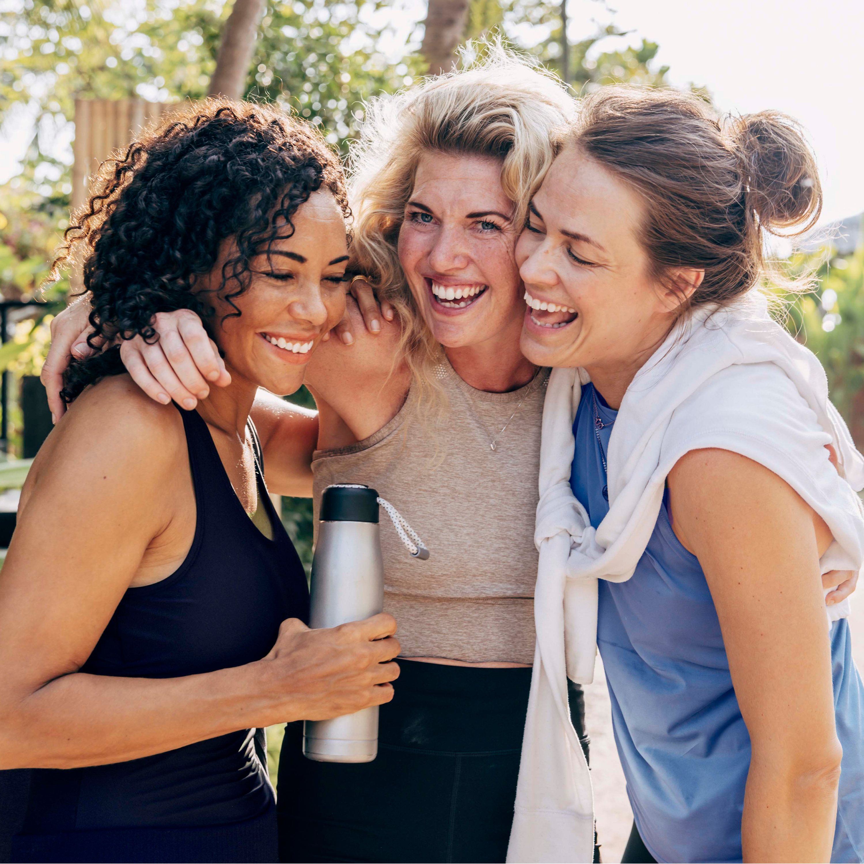 A group of women engaging in a lively and happy conversation outdoors.