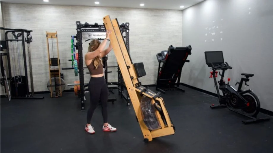 A person easily lifting the end of a WaterRower to store it vertically.
