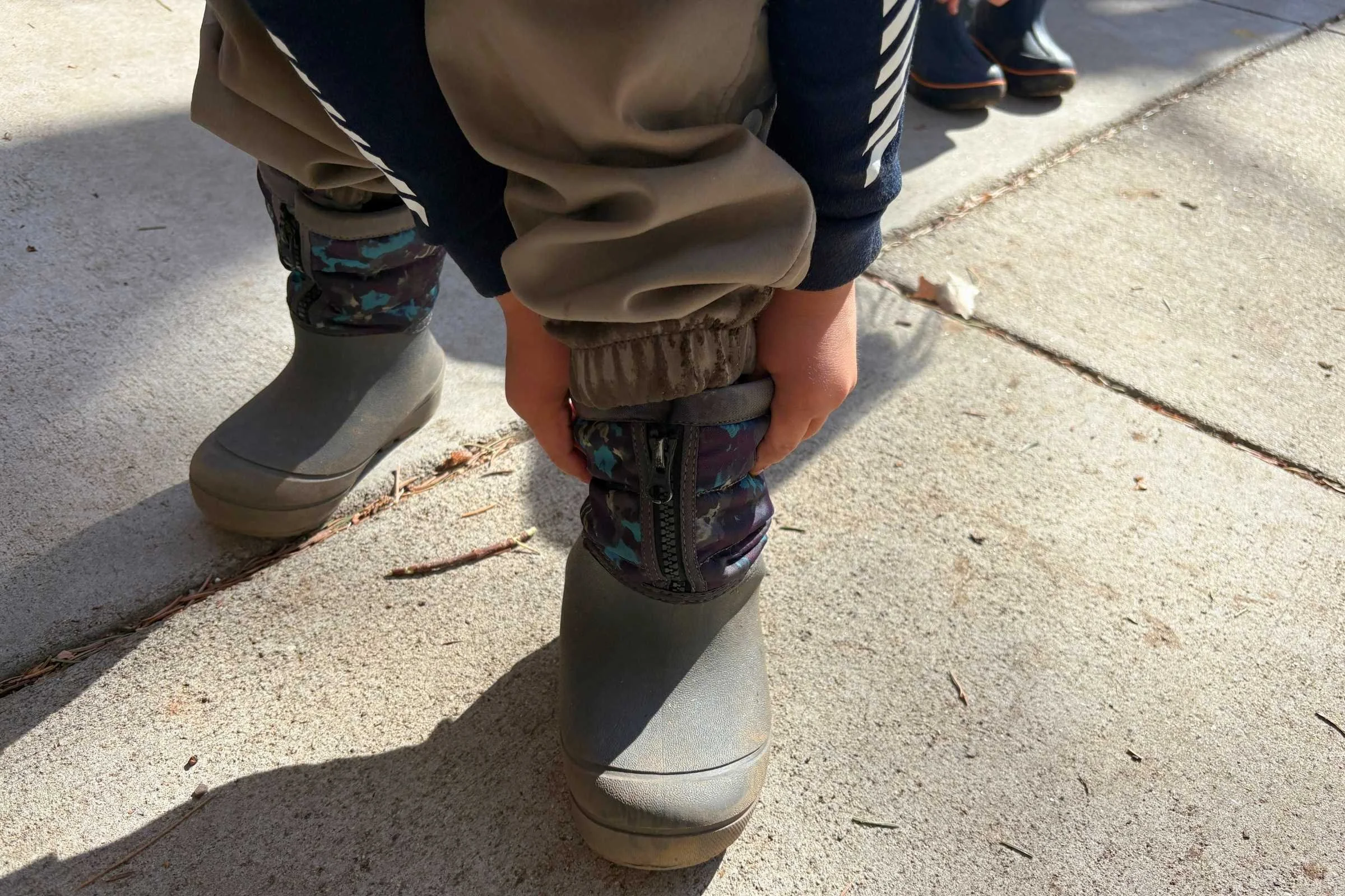 A pair of children's snow boots featuring integrated handles for easy pulling on.
