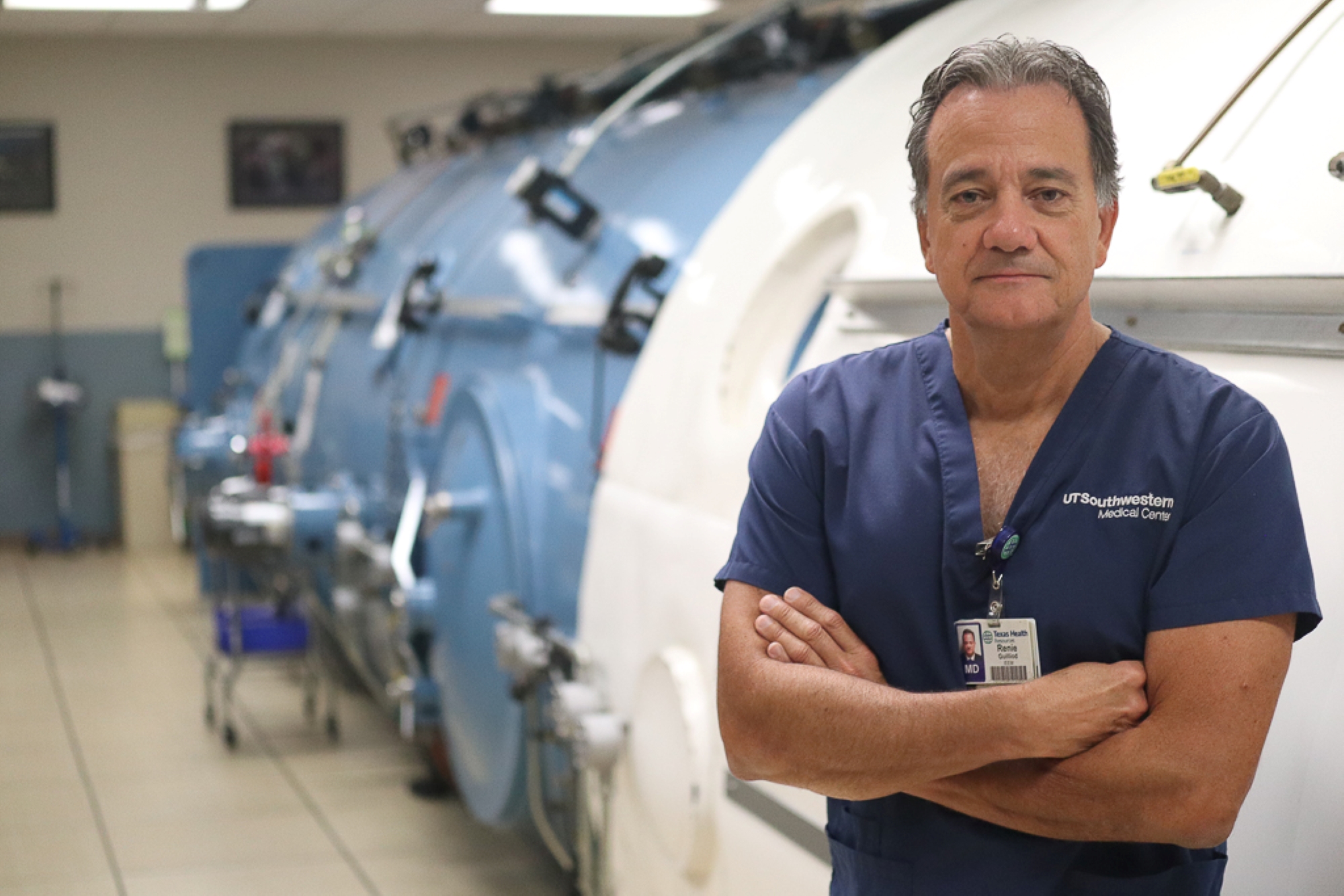 A medical specialist standing next to a clinical-grade hyperbaric oxygen chamber.