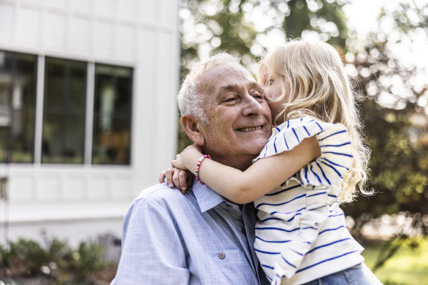 An older man hugging a child outdoors to represent functional health and vitality.