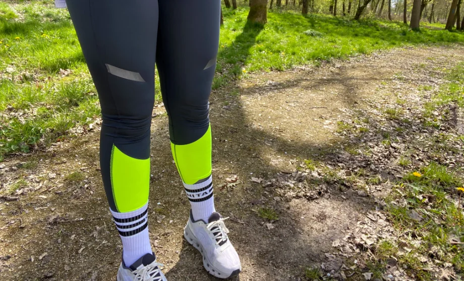 A runner wearing Brooks Run Visible leggings with reflective strips for nighttime safety.