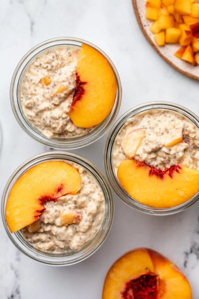 Peaches and cream overnight oatmeal layered in a glass mason jar.