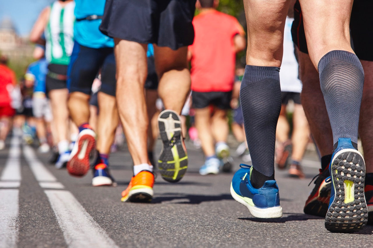 A large group of runners competing during a marathon on a city street.