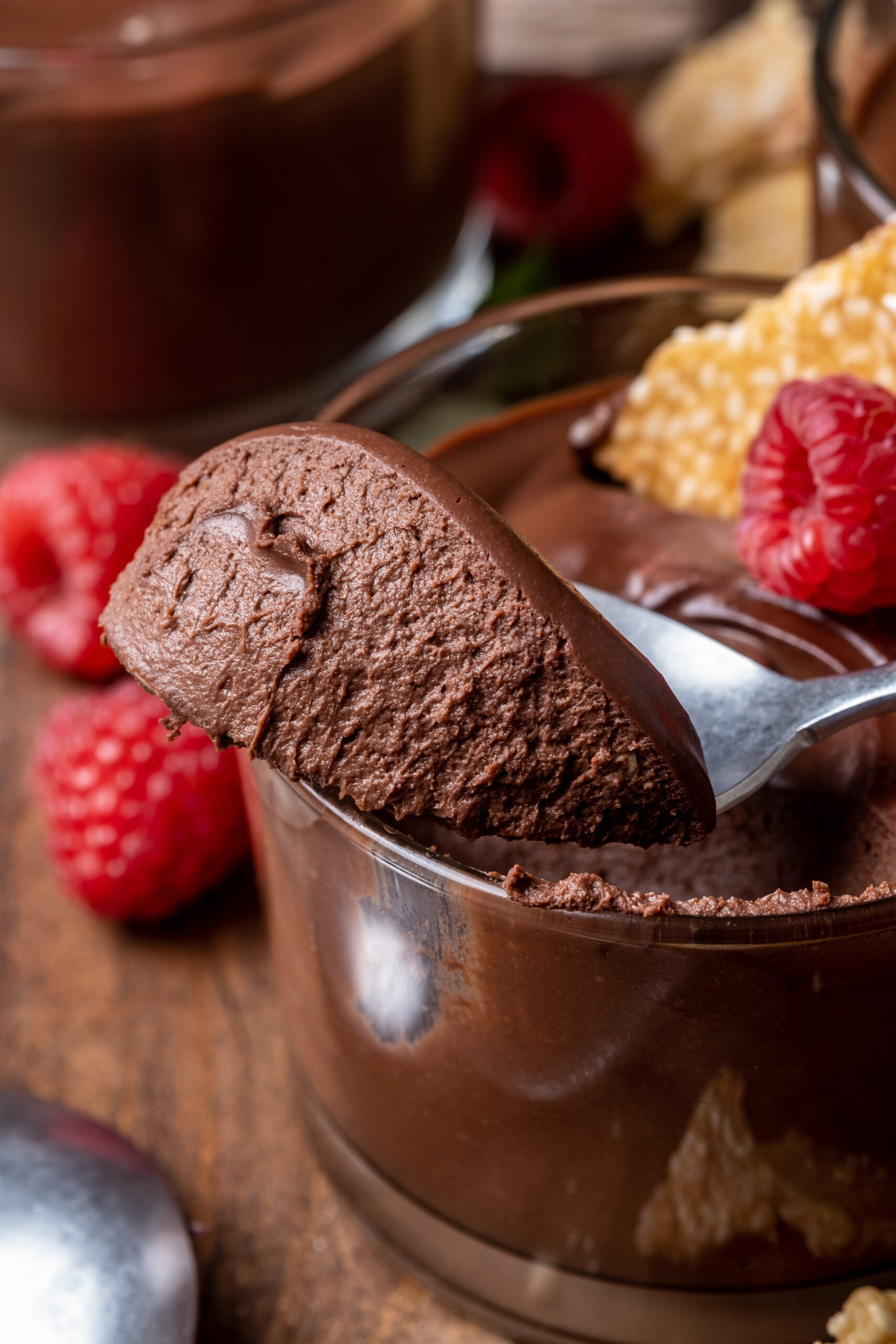 Vegan chocolate tahini mousse served in a white ramekin with brittle pieces on top.