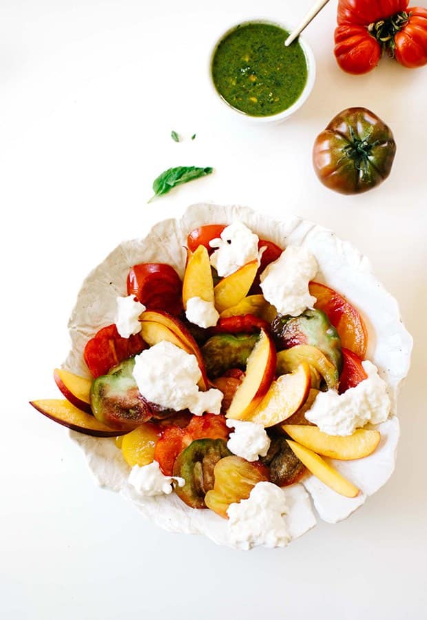 Nectarine and tomato caprese salad with burrata cheese and green pesto.