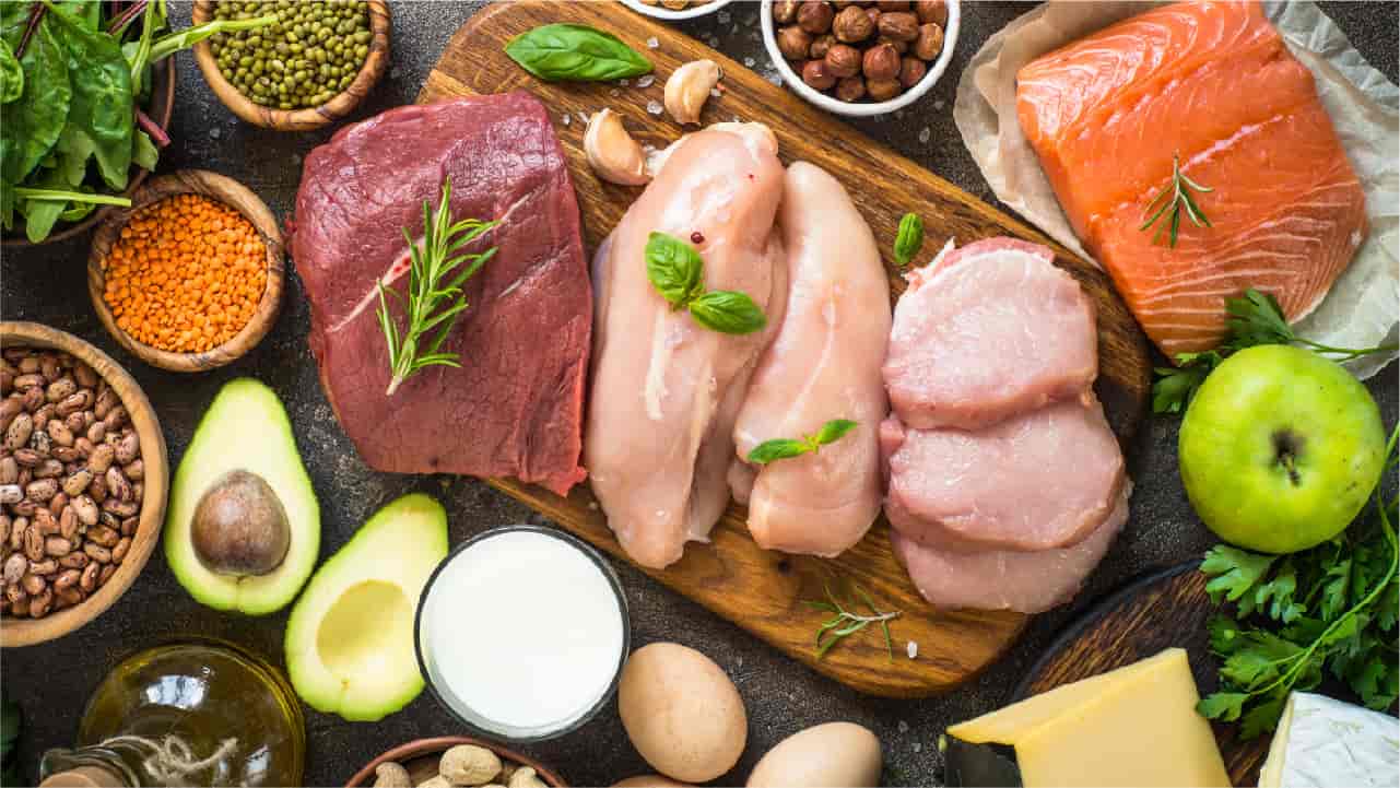 A spread of keto-friendly foods including salmon, leafy greens, and healthy fats.