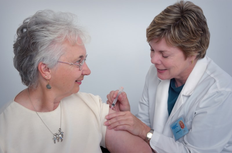 A doctor reviewing multiple prescription medication bottles with a senior patient.