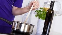 A person preparing food in a kitchen, representing general safety awareness for narcolepsy patients.