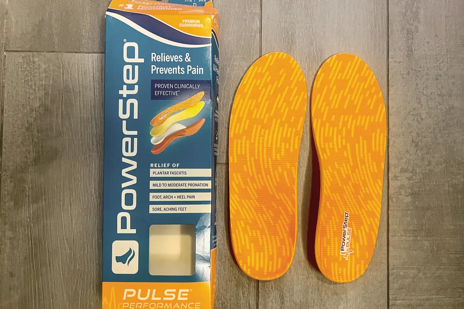 PowerStep PULSE Performance insoles next to packaging that lists relief for plantar fasciitis and arch pain.