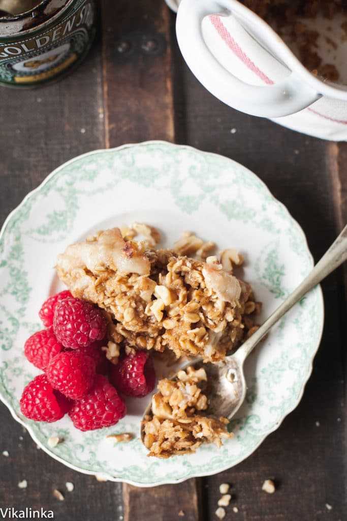 A white baking pan filled with golden-brown baked oatmeal topped with neatly arranged thin pear slices.
