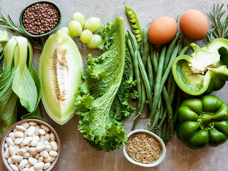A vibrant flat-lay of healthy ingredients including greens, beans, and peppers.