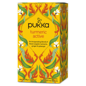 Pukka Turmeric Active Tea box and a warm cup of tea on a table.