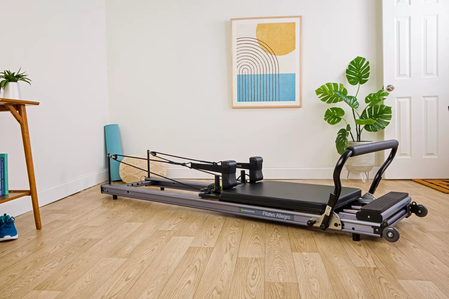 A Balanced Body Allegro Reformer placed in the corner of a residential room with sufficient clearance for movement.