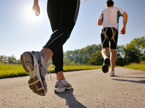A person in athletic gear walking briskly outdoors for exercise.