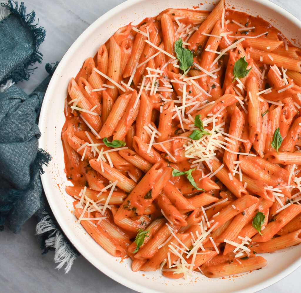 A bowl of Penne Alla Vodka with a creamy orange-colored sauce.