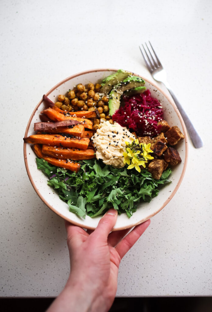 A colorful nourish bowl topped with nutrient-dense seeds and fresh ingredients.