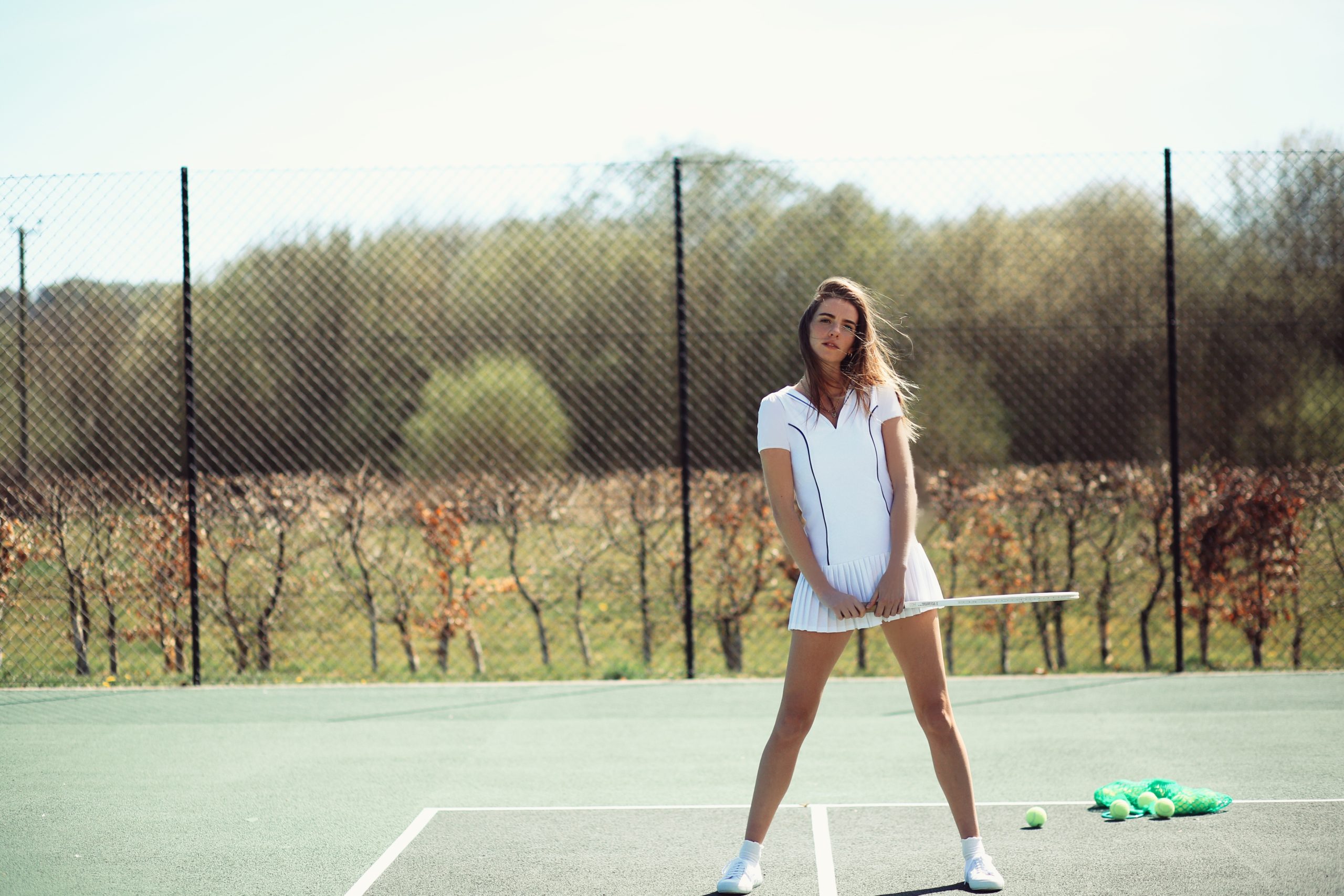 Stylized text overlay 'All White: 7 Reasons Why Tennis Is So Hot Right Now' with a fashion focus.