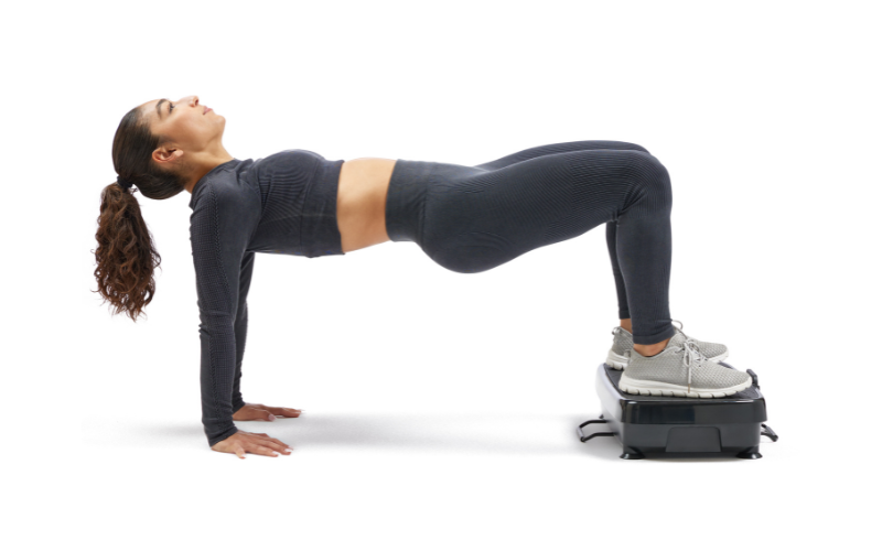 A person holding a plank position with hands on a vibration platform.