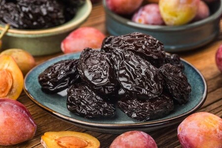 A handful of dark, textured dried prunes.