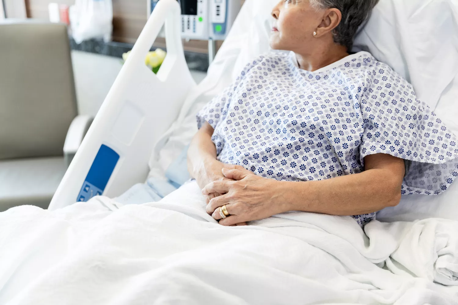 A person lying in a hospital bed, highlighting the medical dangers of inaccurate glucose monitoring.