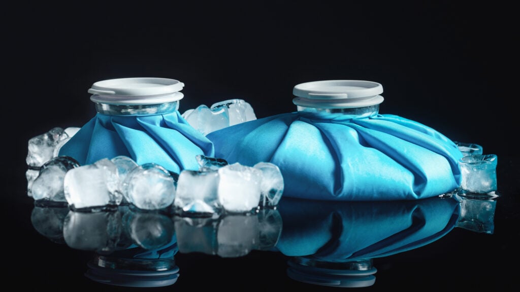 A blue cold therapy ice pack being held against a person's skin.