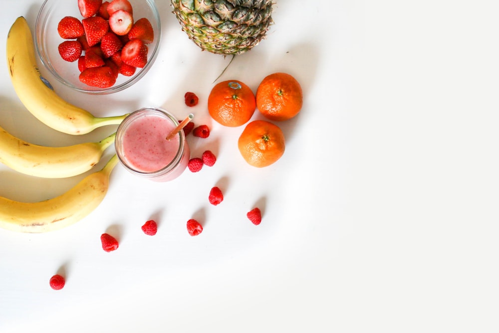 Assorted fresh citrus fruits and strawberries arranged on a surface.