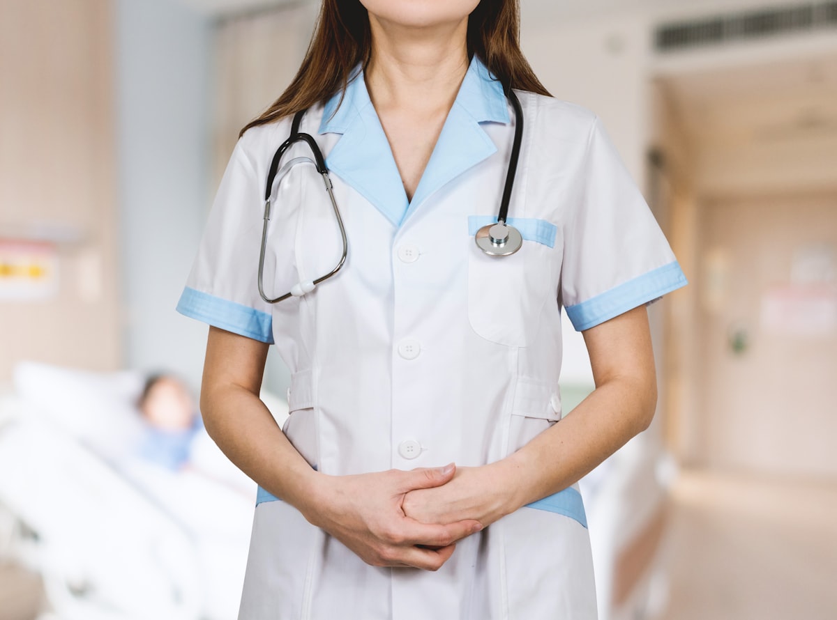 A medical professional in a lab coat preparing a patient for a cryotherapy session.