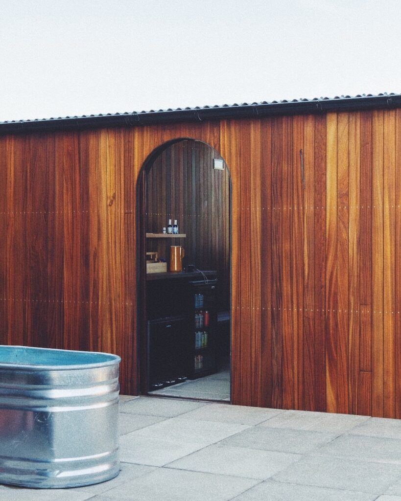 A row of outdoor cold plunge tubs on a modern rooftop terrace overlooking the city.