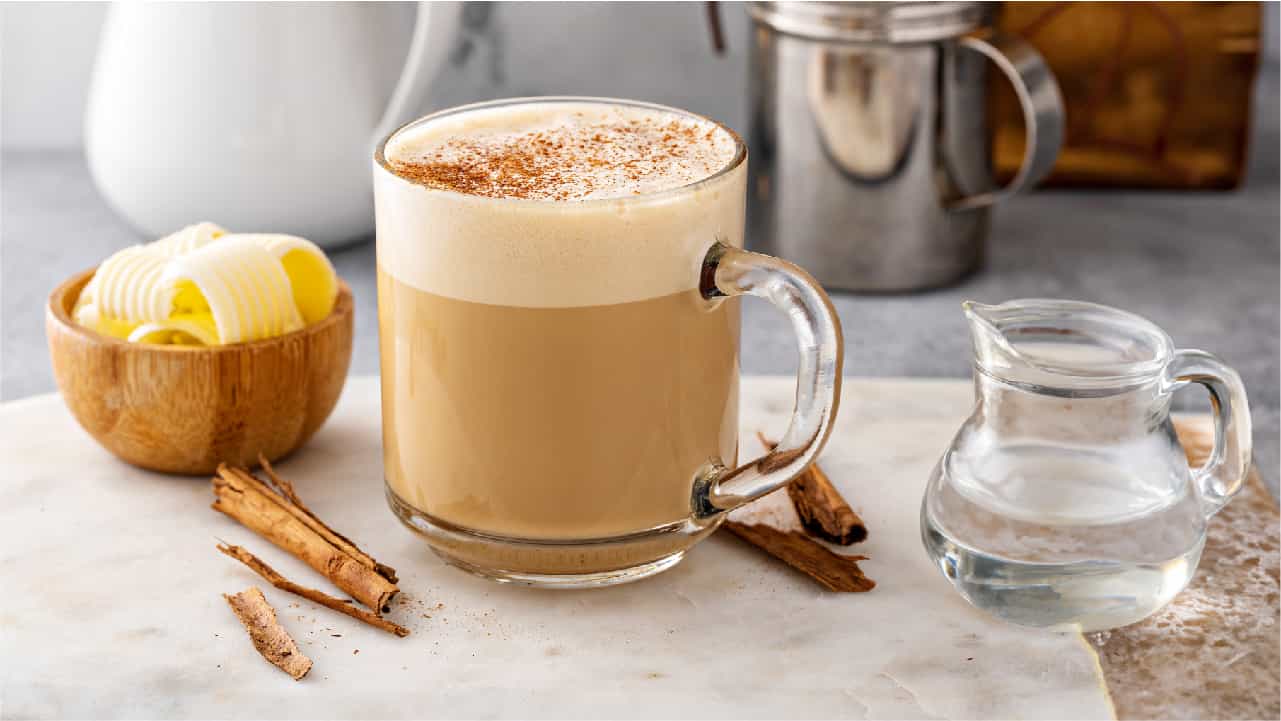 A person preparing a fresh cup of coffee and adding MCT oil.