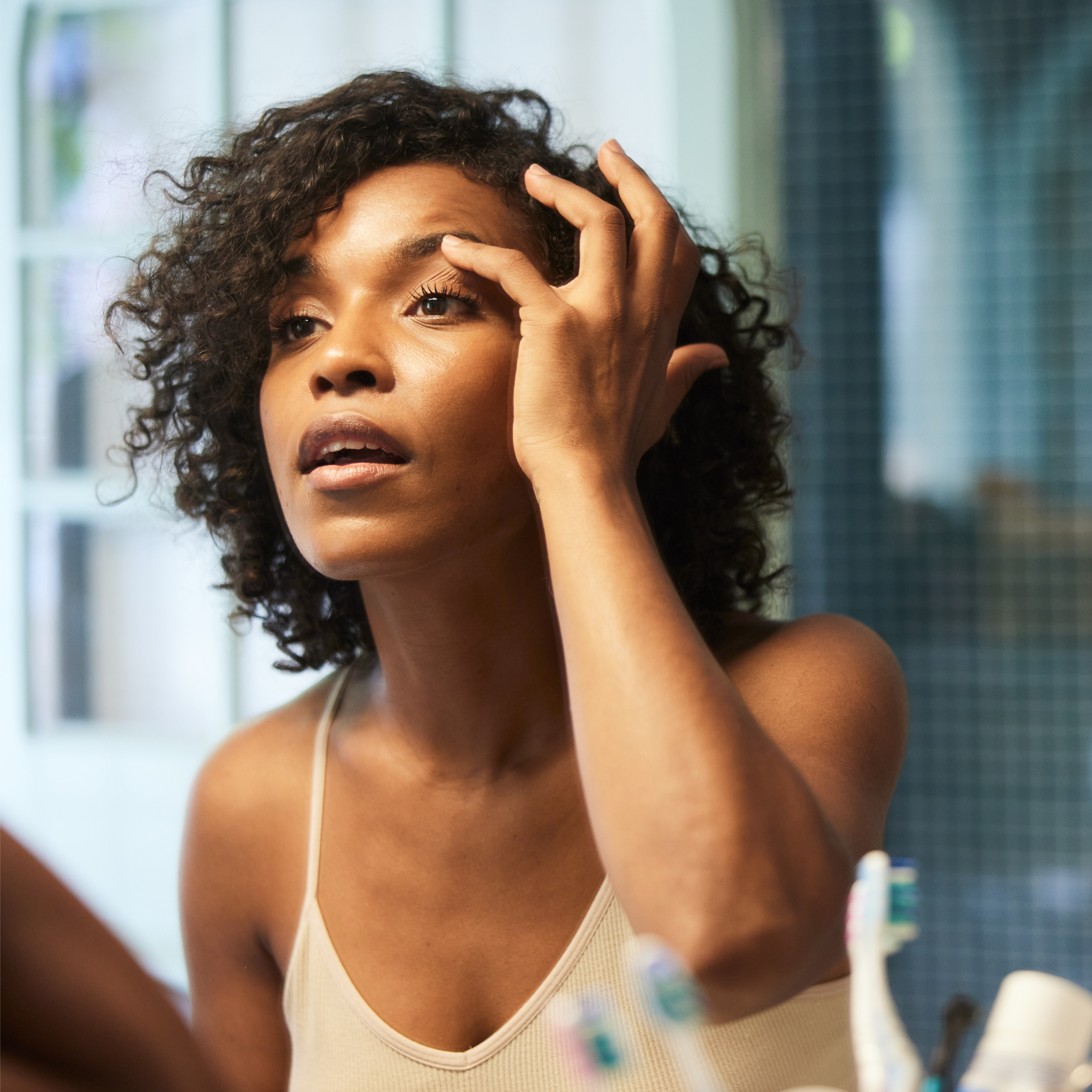 A middle-aged woman looking at her reflection in a mirror, focusing on her well-being.