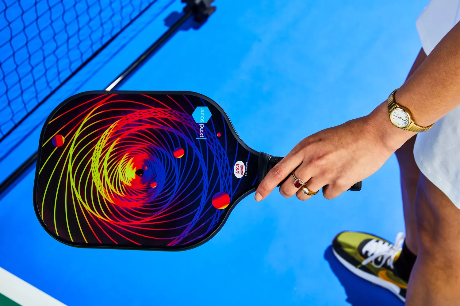 A player holding a fiberglass pickleball paddle set.