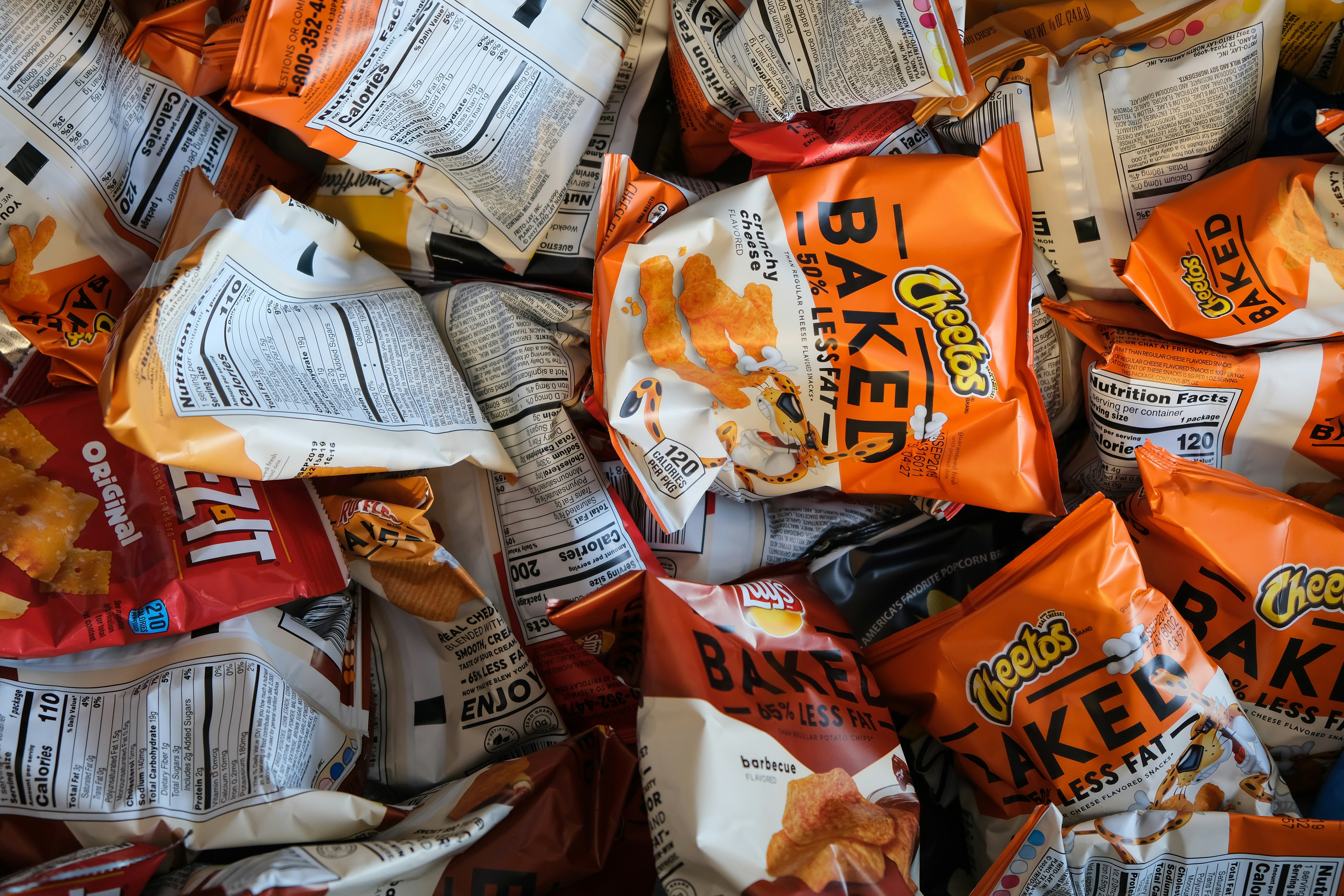 A close-up shot of crispy potato chips in a bowl representing high-intake processed snacks.