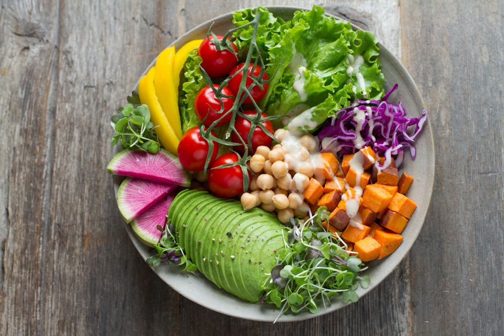 A fresh green salad bowl containing nutrient-dense vegetables and seeds.