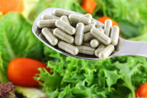A side-by-side comparison of a fresh green salad and fiber supplement capsules.