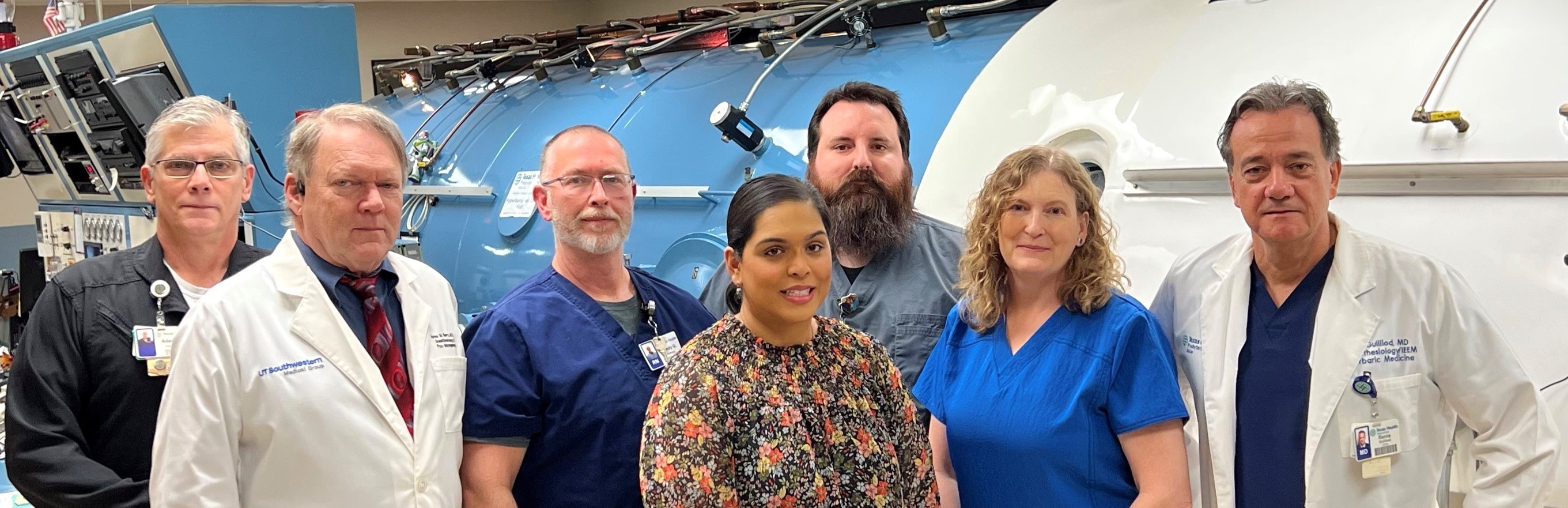 A team of medical professionals specialized in hyperbaric medicine standing in front of their facility.